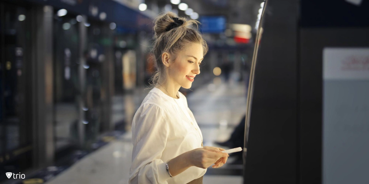 Frau kauft ein U-Bahn-Ticket über eine interaktive Kiosk-Software.