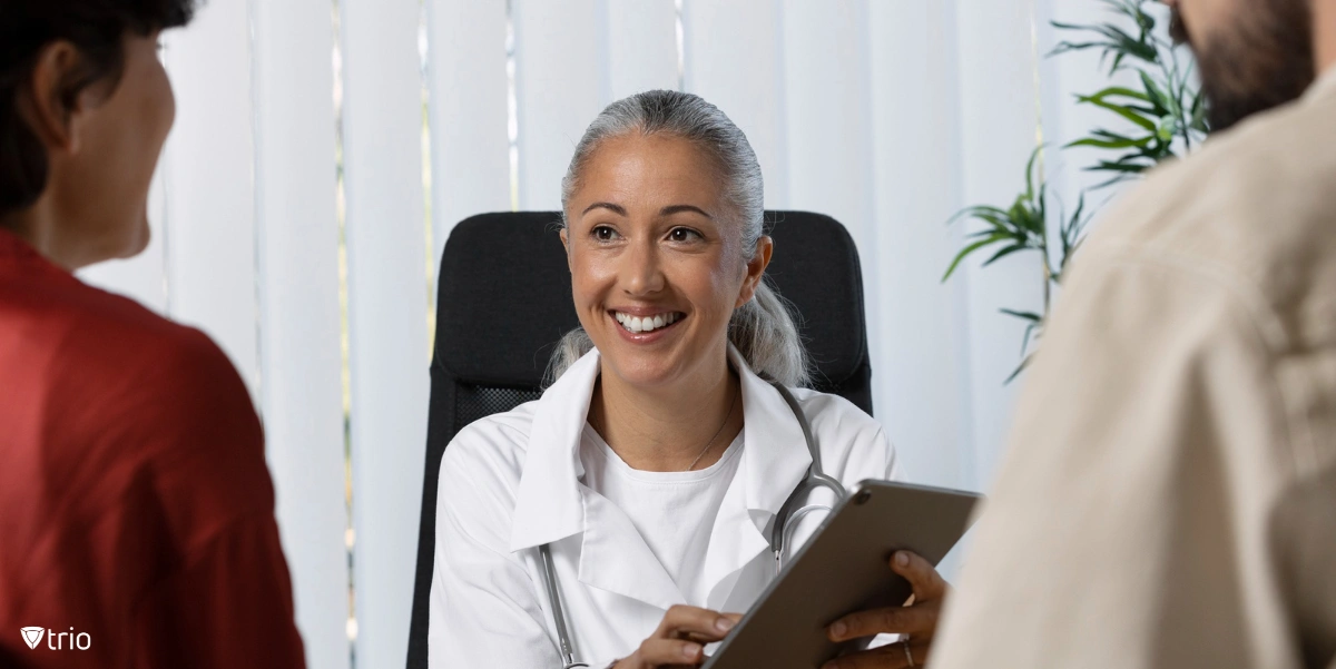 Smiling doctor listening to patient’s medical data history