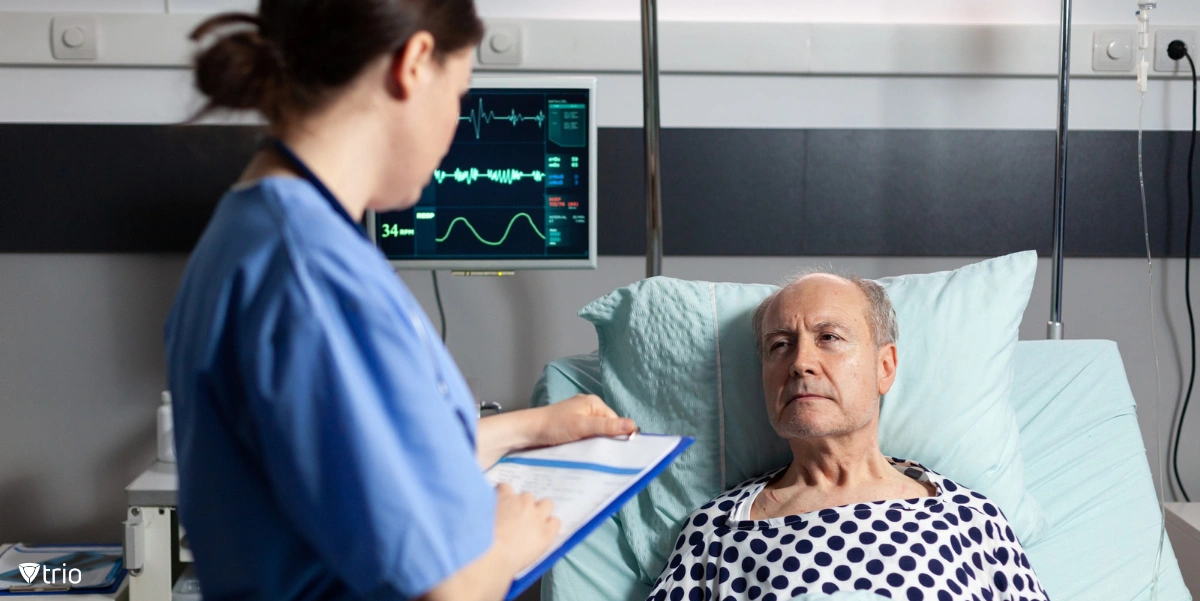 Old man as a patient in hospital bed talking to a doctor