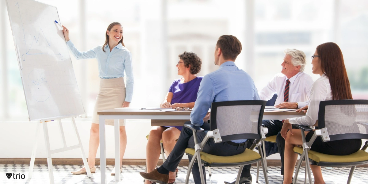 Employees attentively watch a presenter in an office setting during a training session on cybersecurity.