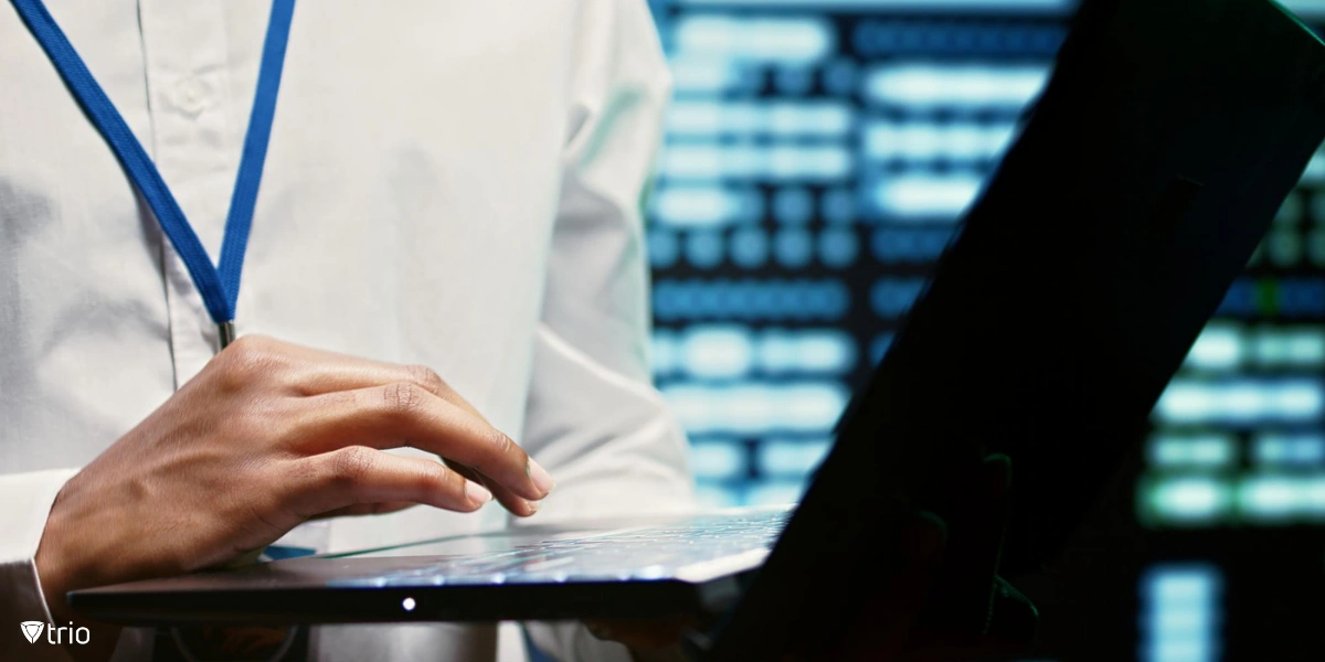 Person with a laptop in a server room conducting security assessments, analyzing system vulnerabilities to enhance overall cybersecurity and data protection.