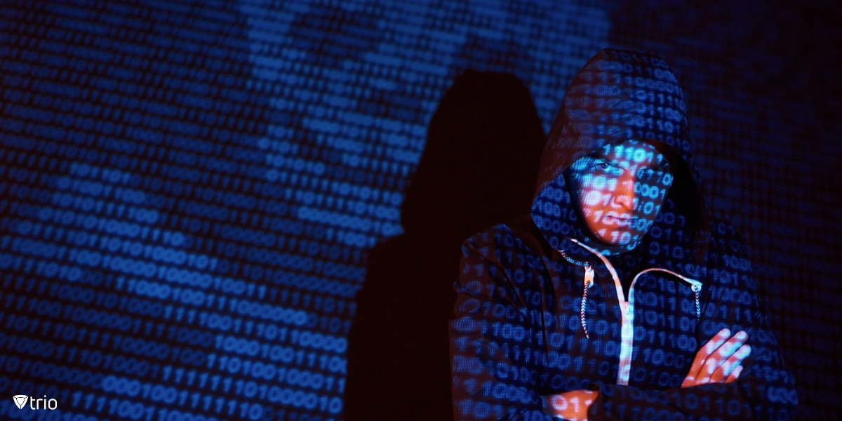 A hooded hacker in a dark environment interacts with virtual screens.