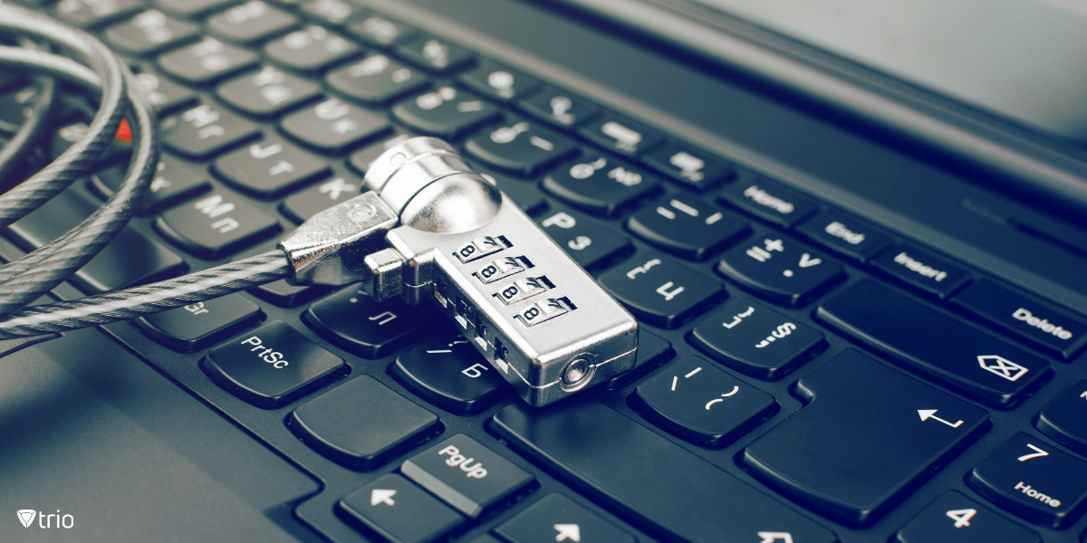 A computer keyboard wrapped in a metal chain with a padlock.