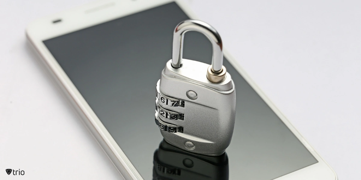 A physical padlock secured on a smartphone.