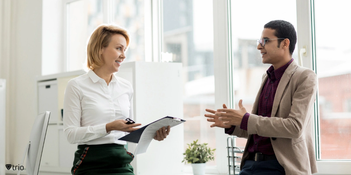 Office workers engaged in a discussion, symbolizing collaboration and communication as key components of building a strong safety culture in the workplace.