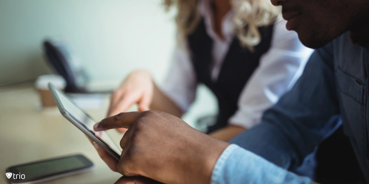 Business professionals using a tablet in a work setting, highlighting the growing reliance on mobile devices for work and the importance of securing them.