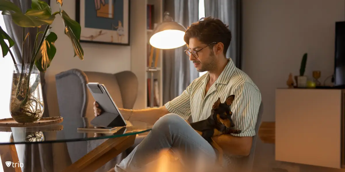  [Remote-Arbeit mit sicherer Konnektivität ermöglichen] [Mann arbeitet aus der Ferne mit Hund auf dem Schoß zu Hause] 