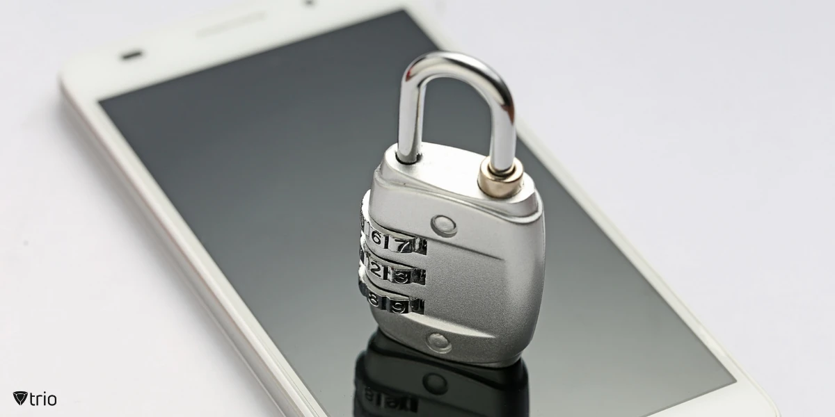 Close-up of a smartphone screen with a physical padlock on it, symbolizing encryption.