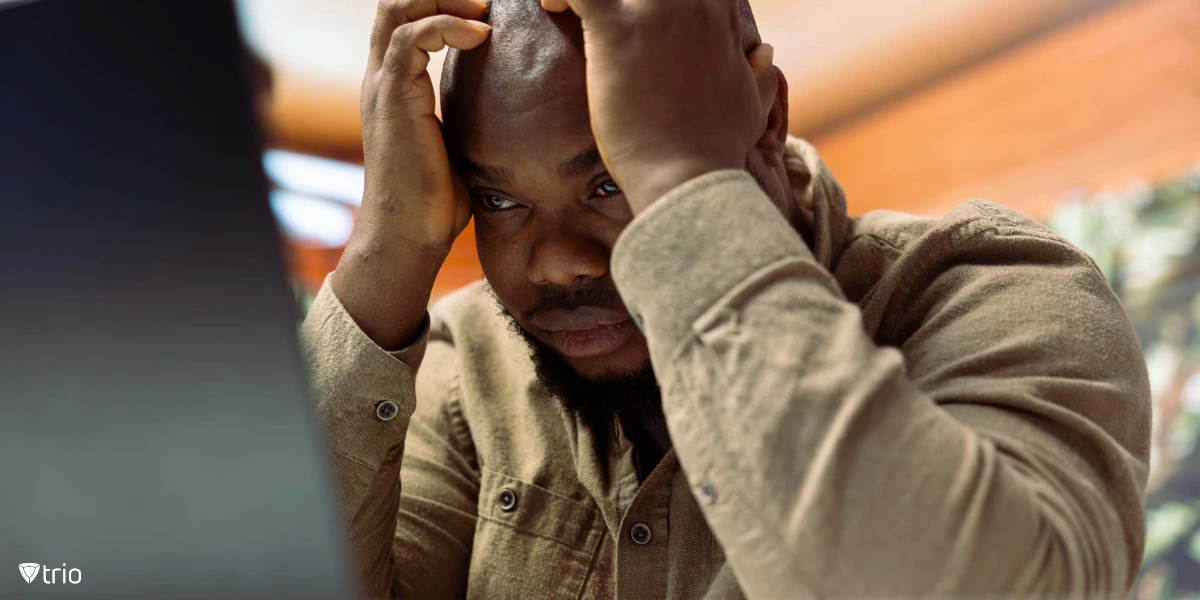 Stressed software engineer overwhelmed by deadlines, sitting behind a computer.