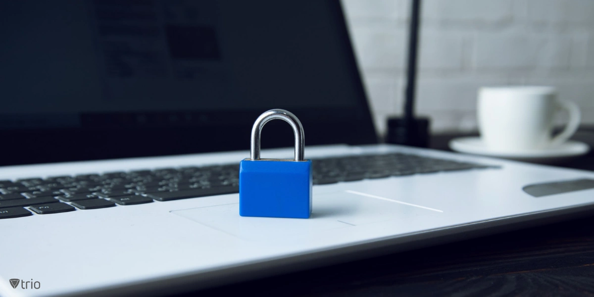 A close-up of a laptop placed on a desk, with a prominent blue lock on its keyboard.