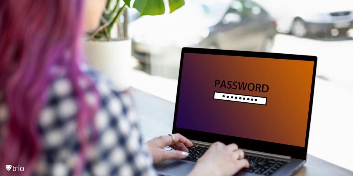 Back view of a woman sitting in a cafe while typing on laptop with password login screen