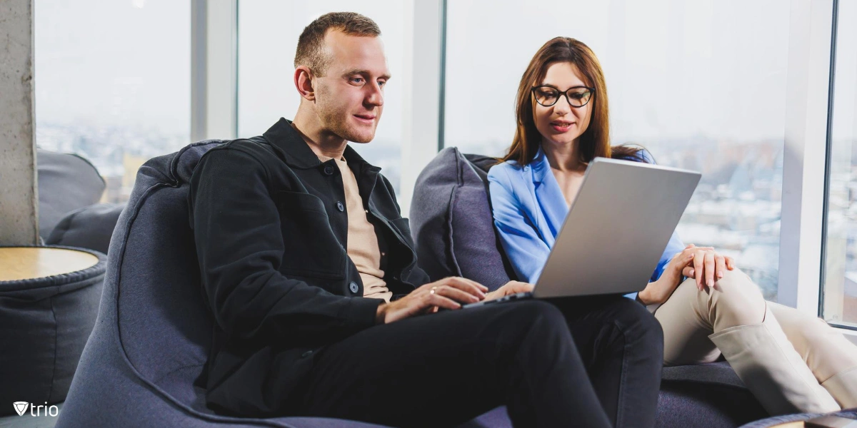 Two colleagues working on one laptop