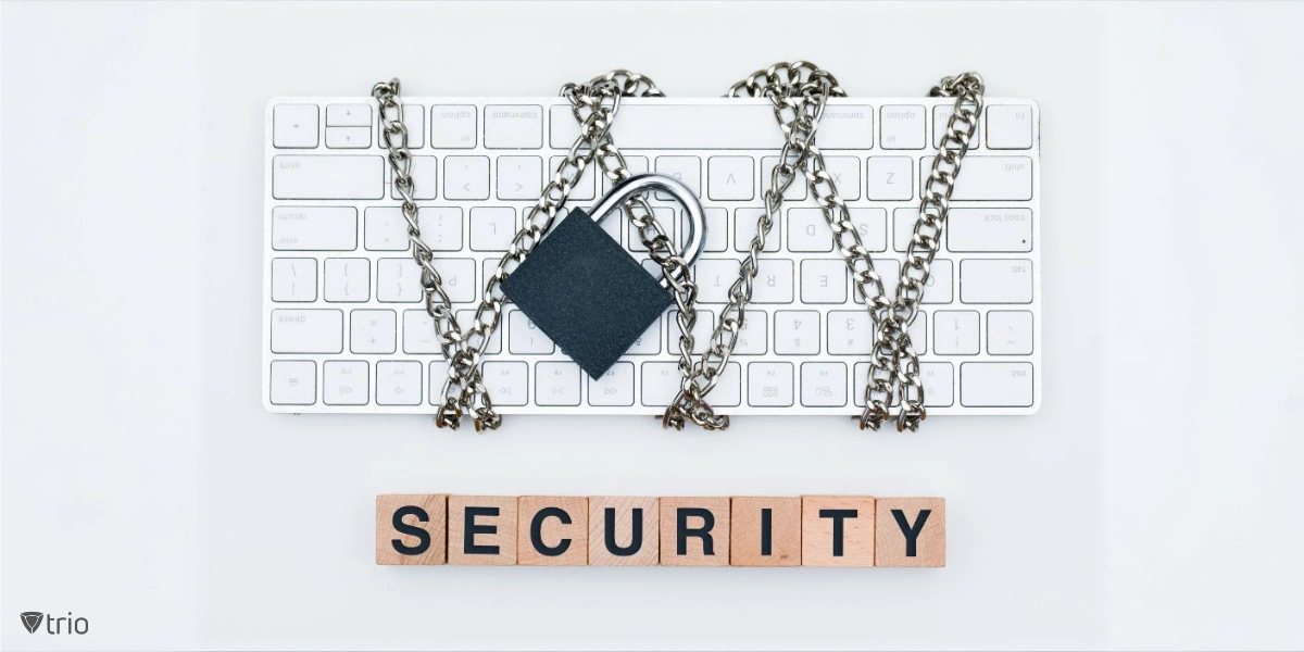 A computer keyboard is wrapped in chains and secured with a padlock. Below the keyboard, wooden blocks spell out the word "SECURITY