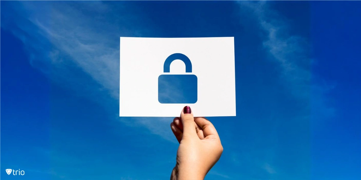 A hand holds up a white sheet of paper with a padlock cut-out against a bright blue sky