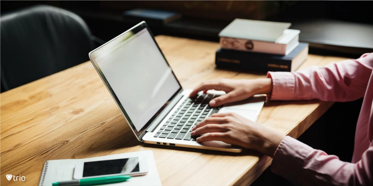 Businessman holding folder icon while sitting in front of laptop