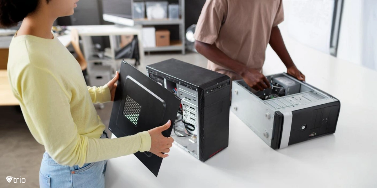 Two individuals assembling or repairing desktop computers, focusing on the hands-on process of managing hardware components