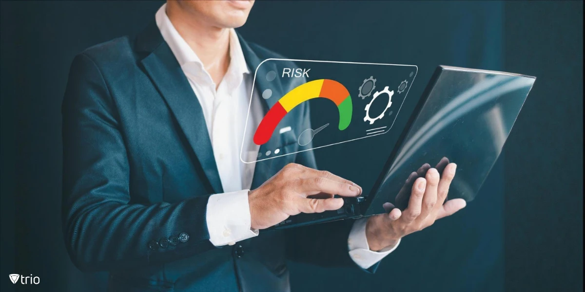 Businessman holding laptop with virtual risk level indicator from low to high