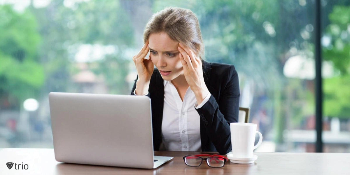 upset woman with hands in her hair looking at laptop