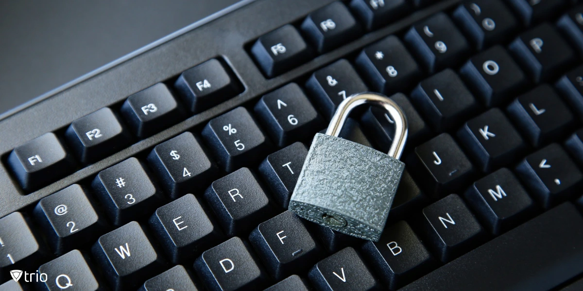 A close-up shot of a black computer keyboard with a silver padlock placed on top of it.