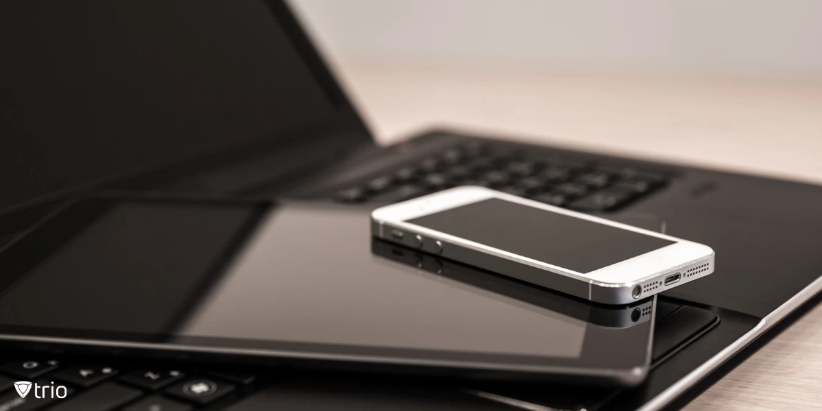 A neatly arranged stack of electronic devices—including a laptop, tablet, and smartphone