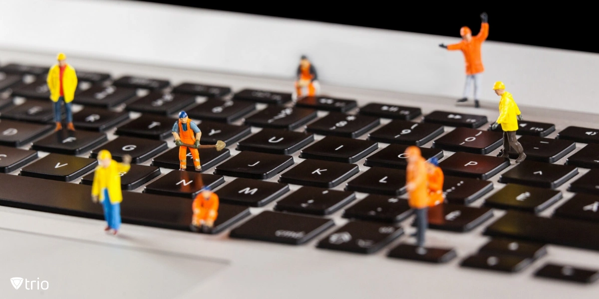 Worker figures working on a laptop keyboard